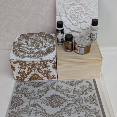 Produtos de artesanato com stencil floral, caixas decoradas e frascos de tinta CADENCE sobre mesa branca