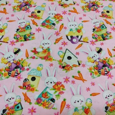 Tecido com padrão de coelhos, casas de pássaros e cenouras sobre fundo rosa