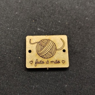 Etiqueta de madeira gravada com bola de lã e texto feito à mão