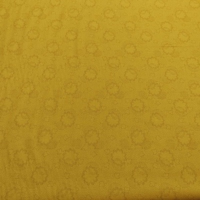 Tecido amarelo com padrão subtil de círculos e texturas