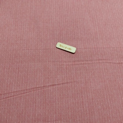 Tecidos rosa com padrão de linhas brancas pequenas e etiqueta clara no centro