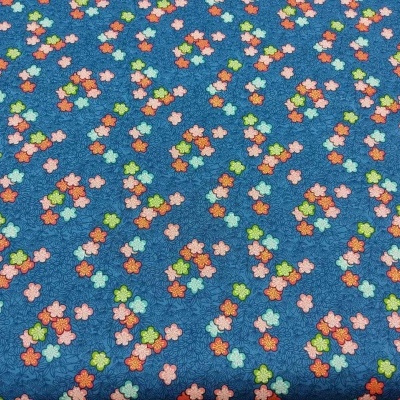tecido azul com padrão de pequenas quatro folhas coloridas