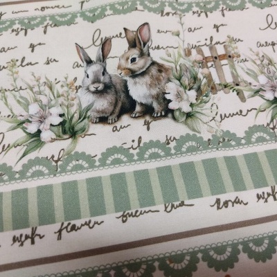 Tecido estampado com coelhos, flores, grades e texto manuscrito