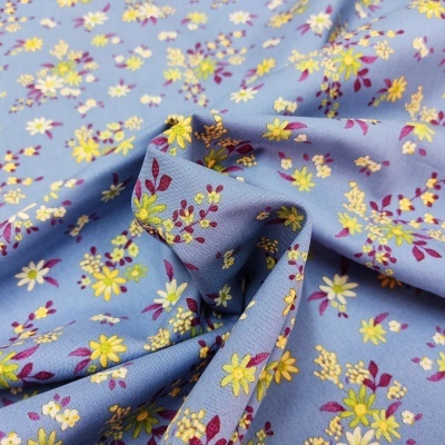 tecido azul claro com padrão floral amarelo, branco e vermelho