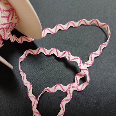 Fita de tecido branca com padrões ondulados cor-de-rosa sobre fundo preto