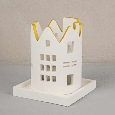 Miniatura de casa branca com detalhes dourados numa base quadrada branca