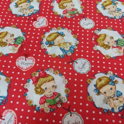 Tecido vermelho com estampa de meninas e bolinhas brancas.