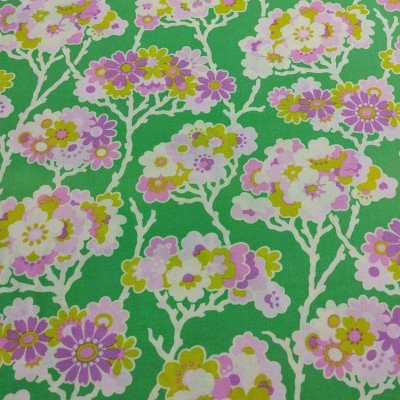 Tecido verde com padrão floral em lilás, amarelo, branco e rosa