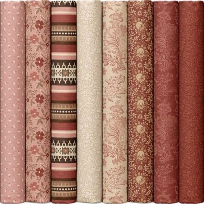 Rolos de tecido com padrões florais e geométricos em tons rosas e castanhos