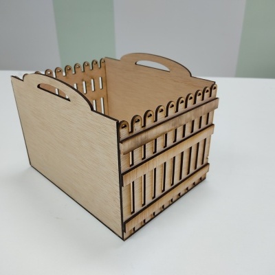 Caixa de madeira clara com recortes e alças