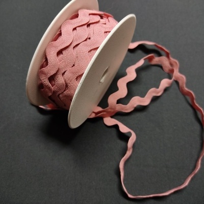 Rolo de fita ondulada cor-de-rosa em fundo preto