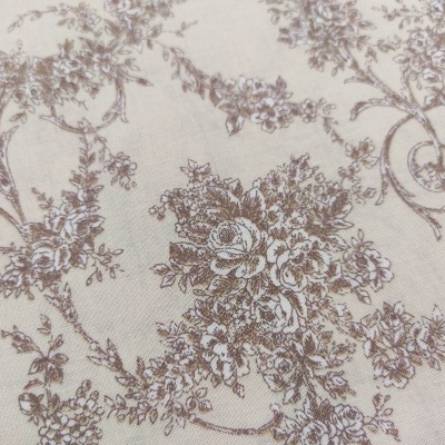 Tecido com padrão floral castanho e bege num fundo claro