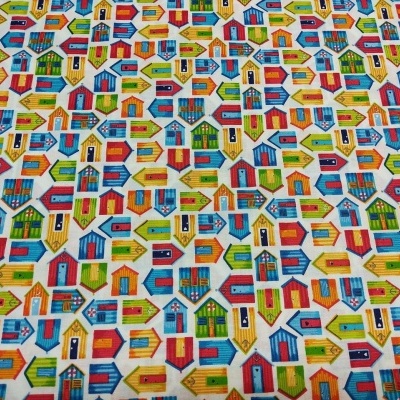 Tecido com padrão de pequenas casas coloridas em fundo branco