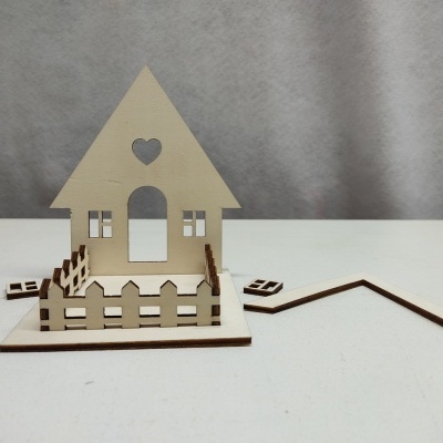 Maquete de casa de madeira clara com cerca e recortes decorativos