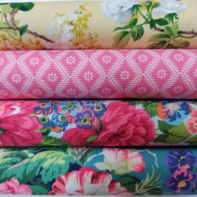Quatro tecidos empilhados com padrões coloridos e detalhes florais