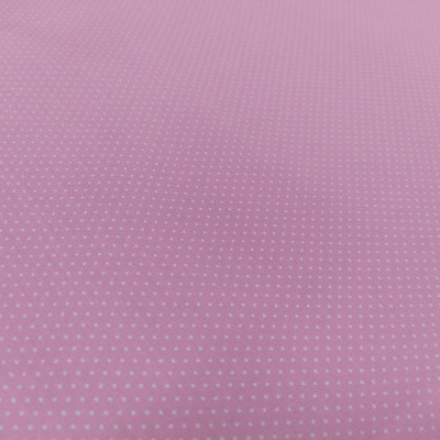 Tecido cor-de-rosa com pontos brancos pequenos espaçados uniformemente