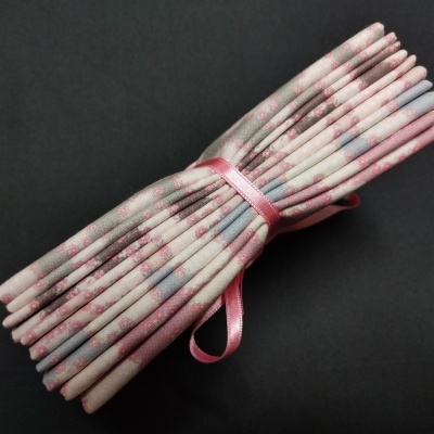 Cordões brancos com padrão floral rosa e fita rosa amarrando-os