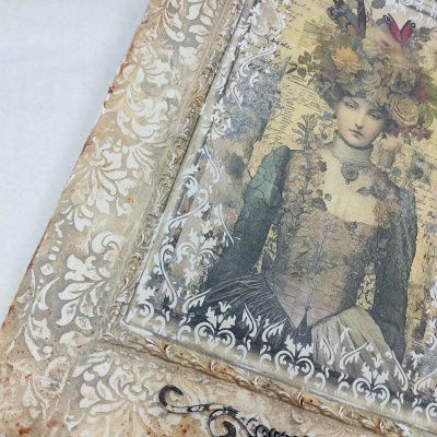 Quadro decorativo vintage com moldura creme e imagem de mulher antiga com flores na cabeça