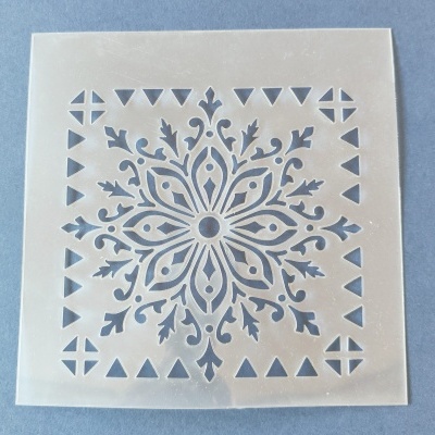 Stencil quadrado branco com padrão de flor estilizada e triângulos