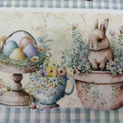 Padrão de ovos coloridos, flores e coelho em suporte e vasos sobre tecido quadriculado azul e branco.
