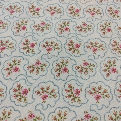 Tecido branco com padrão floral rosa e verde em molduras azuis