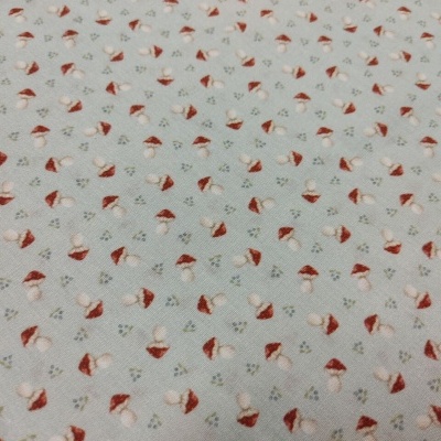 Tecido com padrão de cogumelos vermelhos e bege em fundo cinza claro