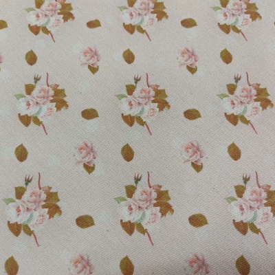 Tecido branco com flores rosa e folhas castanhas em padrão repetitivo