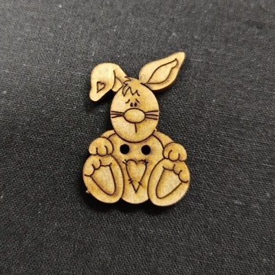 Botão de madeira em forma de coelho com desenhos gravados