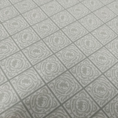 Tecido cinzento claro com padrão geométrico e floral repetido.