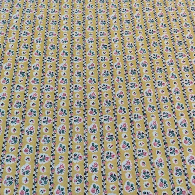 Tecido amarelo com padrão floral em faixas verticais