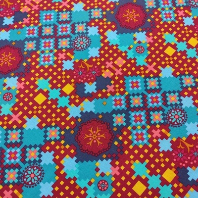 Tecido colorido com padrão geométrico e floral em vermelho, amarelo, azul e vinho