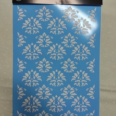 Stencil azul com padrão de folhas recortadas em branco numa embalagem com cabeçalho preto