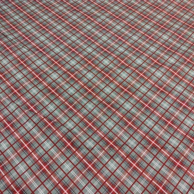 Tecido xadrez vermelho, branco, castanho e cinza em superfície plana