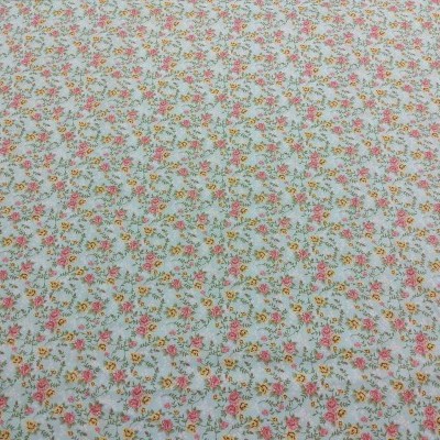 tecido branco com flores pequenas em vermelho, rosa, amarelo e folhas verdes