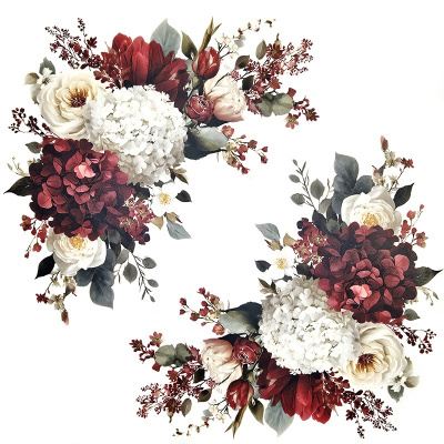 Duas coroas de flores artificiais em tons de branco, vermelho e verde com fundo branco