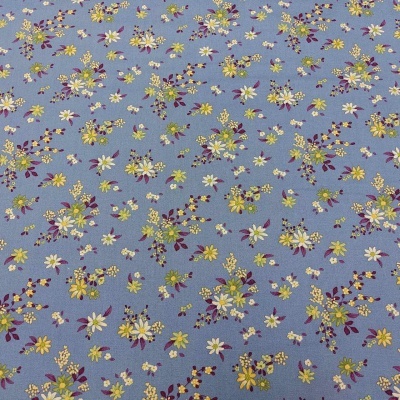 Tecido azul com flores amarelas, brancas e roxas