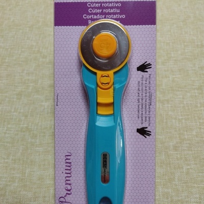 Cúter rotativo azul e amarelo em embalagem lilás com texto IDEAS patch&quilt