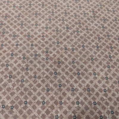 Tecido castanho claro com padrão de losangos e flores azuis pequenas