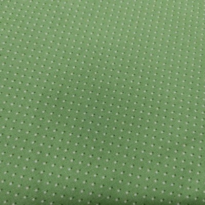 Tecido verde perfurado com pequenos furos circulares