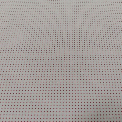 Tecido branco com pequenos pontos vermelhos em padrão repetitivo