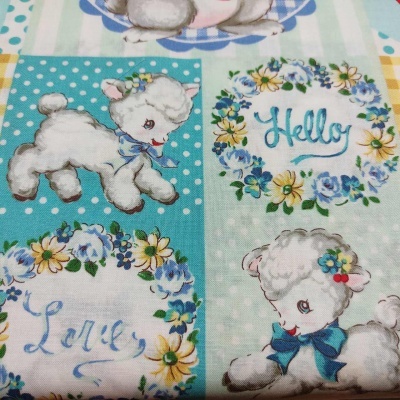 Tecido com padrão de cordeirinhos, flores e texto em azul e amarelo