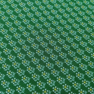 tecido verde com padrão de pequenas flores brancas e amarelas