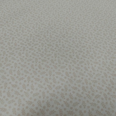 tecido branco com pequenas folhas marrons