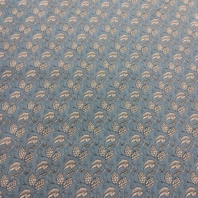 Tecido azul claro com padrão de folhas creme e bege