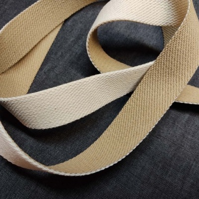 Fitas têxteis bege e castanho claro sobre fundo cinzento