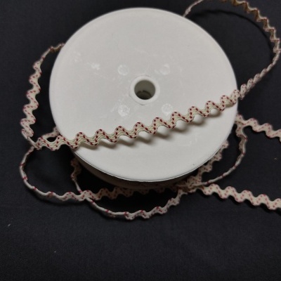 Rolo de fita ondulada bege com linhas vermelhas