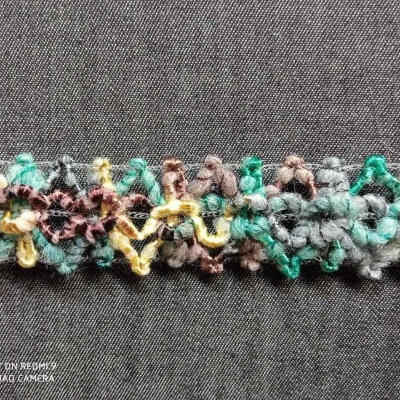 Tecido de crochet colorido com padrão floral sobre fundo cinza escuro