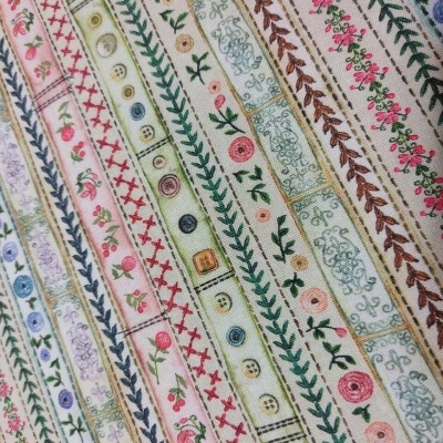 Tecido estampado com riscas horizontais e padrões florais e botões