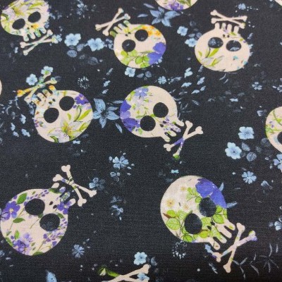 Tecido preto com padrão de caveiras florais lilás e verdes