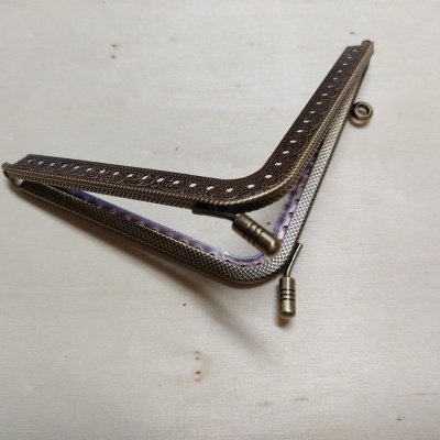 Duas estruturas metálicas curvas castanho escuro e prateada com tubos nas pontas sobre superfície clara